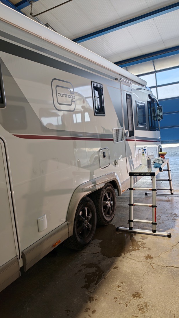 Arbeit am Wohnmobil in der Werkstatt, mit Leiter für die hohen Flächen